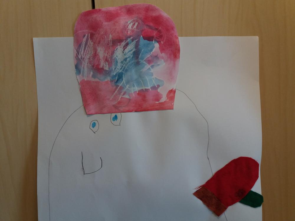 Lapsen piirtämä ja maalama ihminen hattu päässä ja lapanen kädessä.