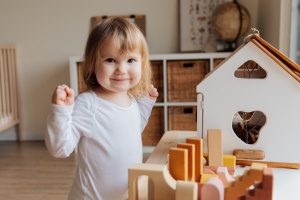 Hymyilevä lapsi rakentelee palikoilla.